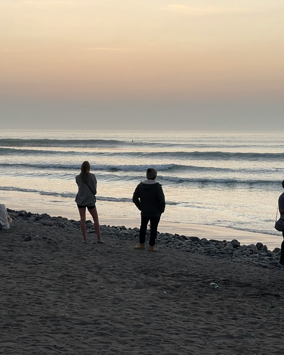 A group of people standing on top of a beach