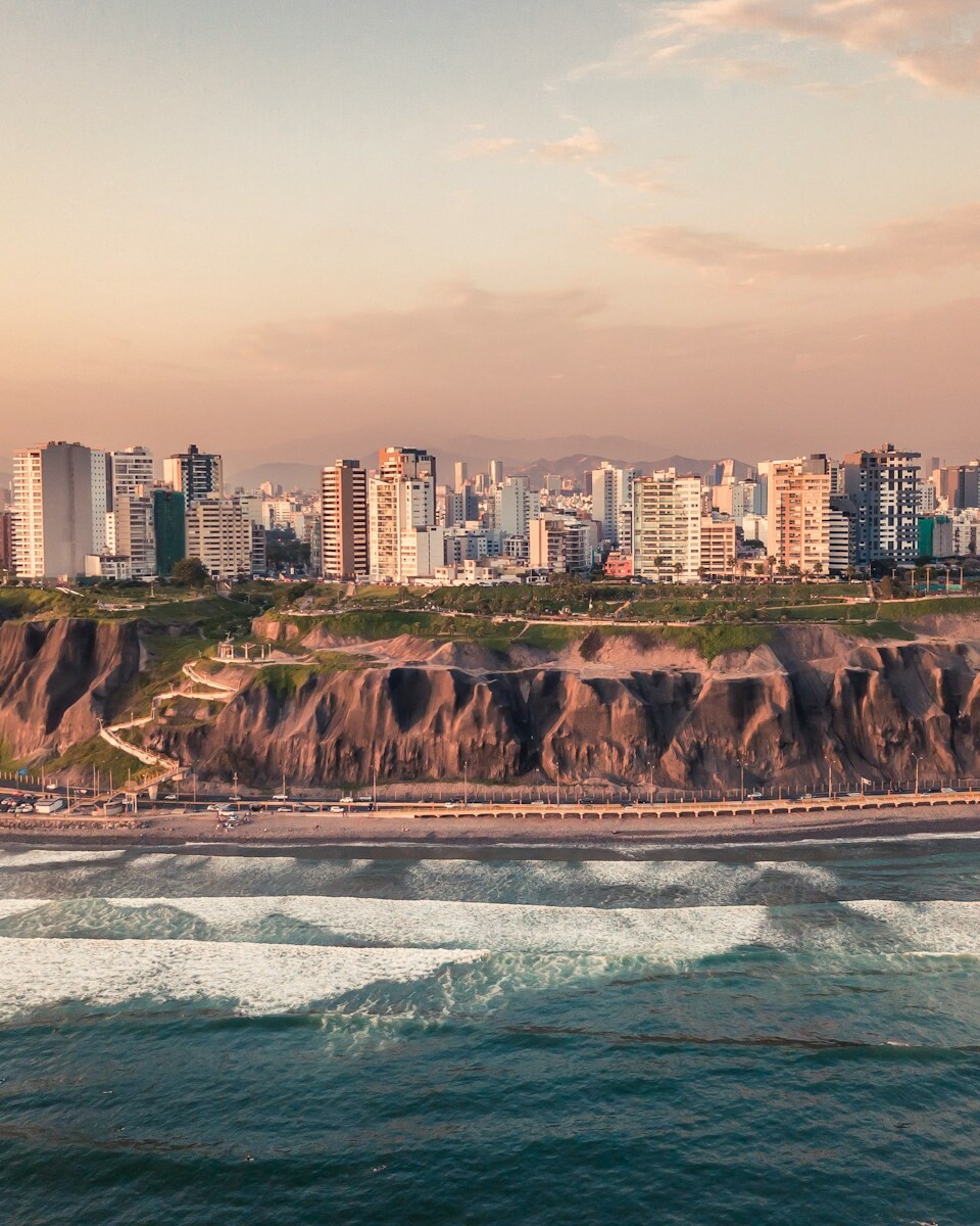 road near body of water and buildings at daytime