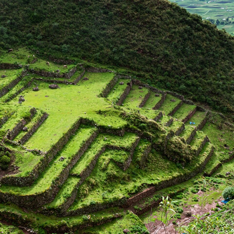A very large grassy hill with a very long structure on top of it