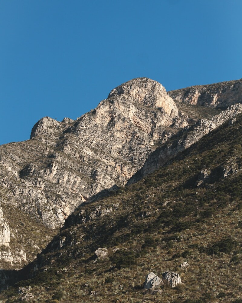 a rocky mountain with a blue sky